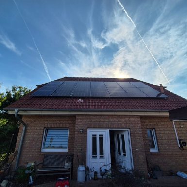 PV-Anlage auf Hausdach mit blauem Himmel.