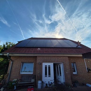 PV-Anlage auf Hausdach mit blauem Himmel.