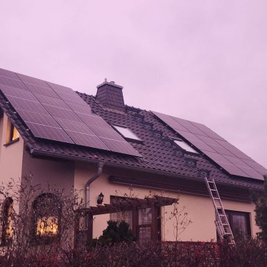 Haus mit Solaranlage in Abenddämmerung.