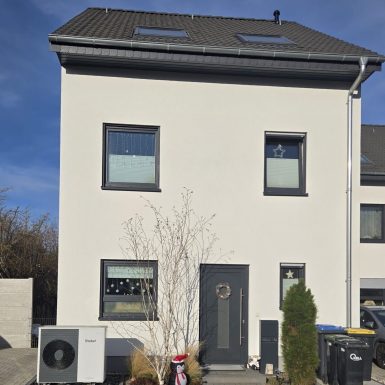 Einfamilienhaus mit Wärmepumpe davor